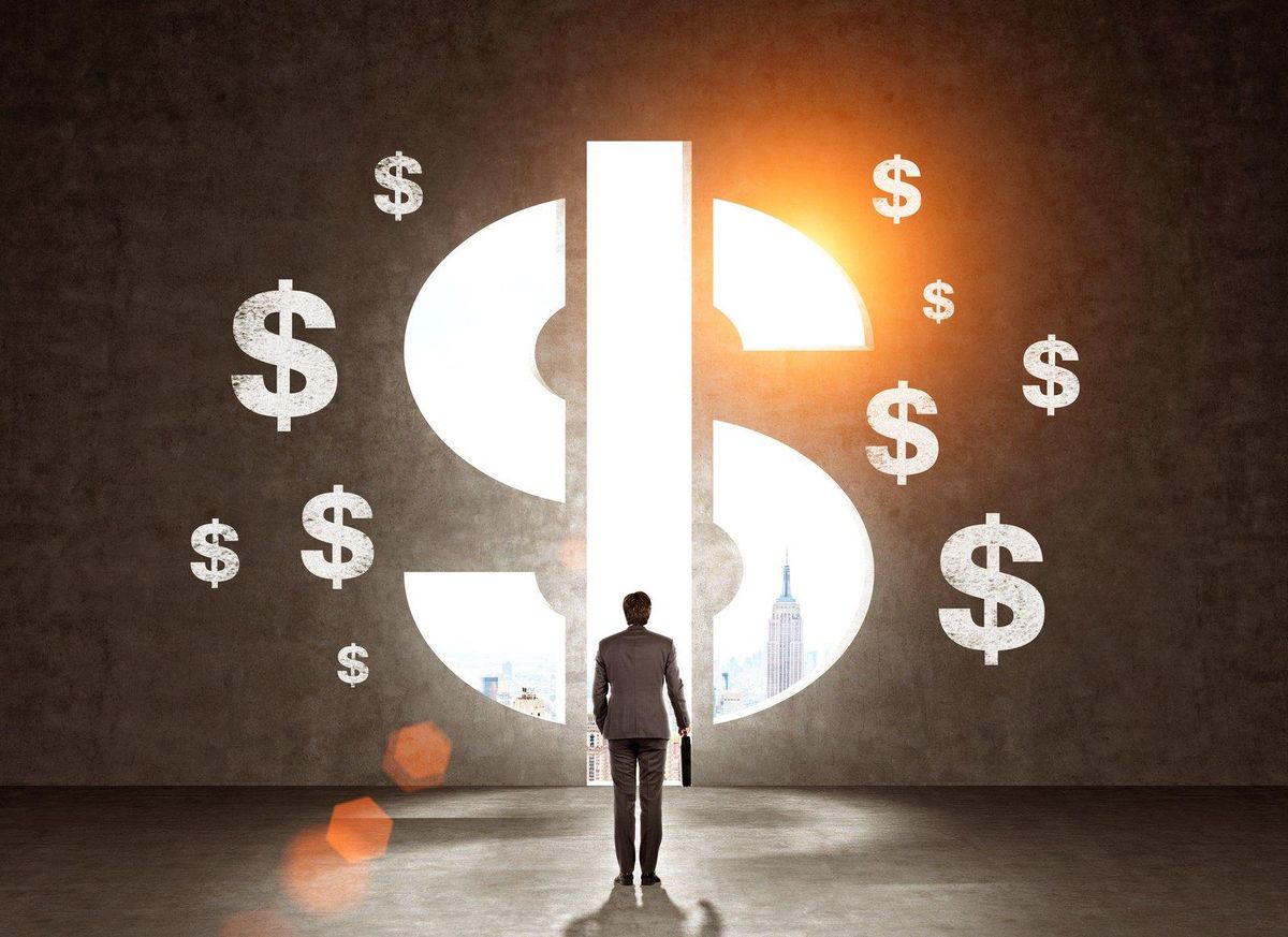 Businessman in suit looking at wall with dollar signs