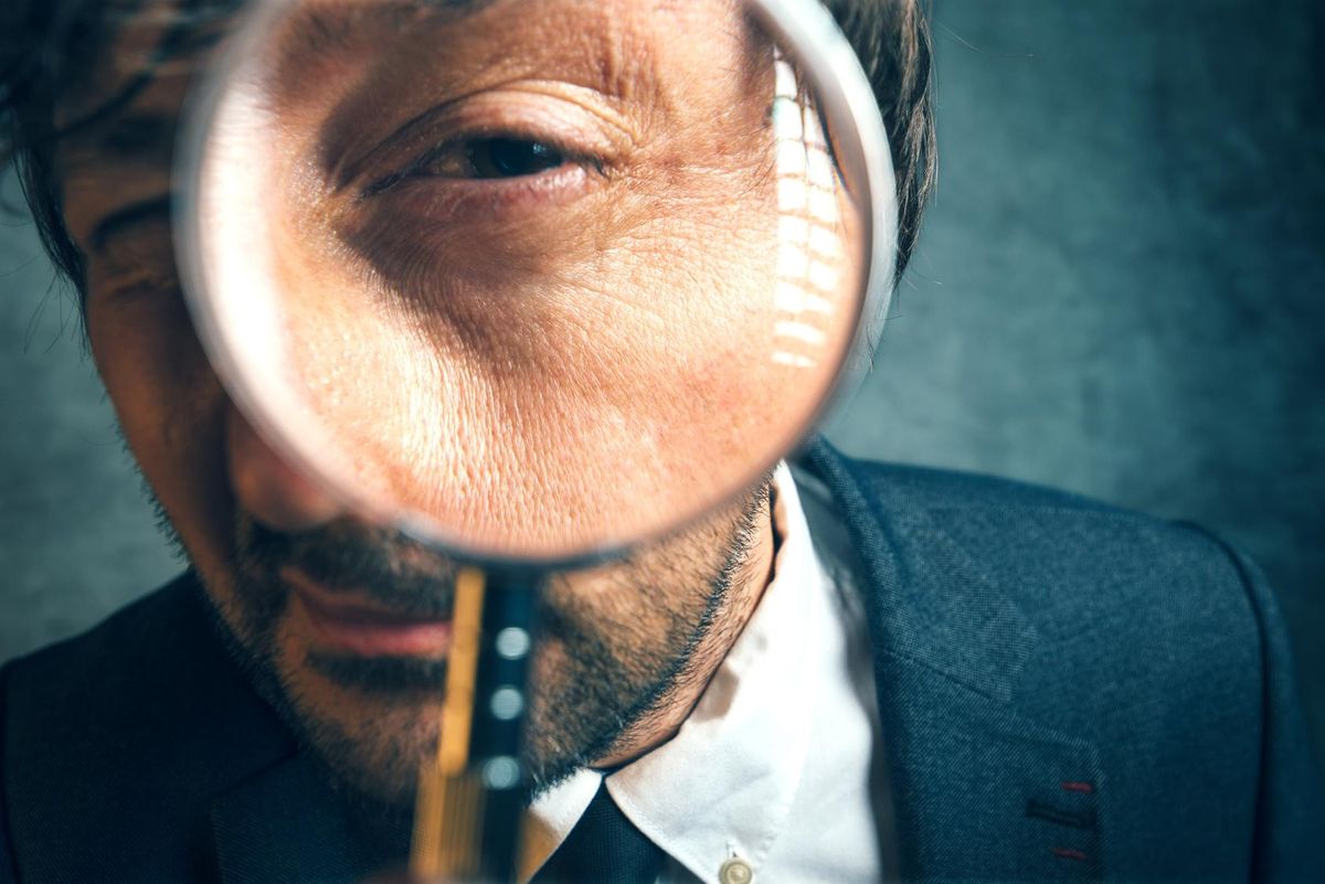 businessman looking through magnifying glass
