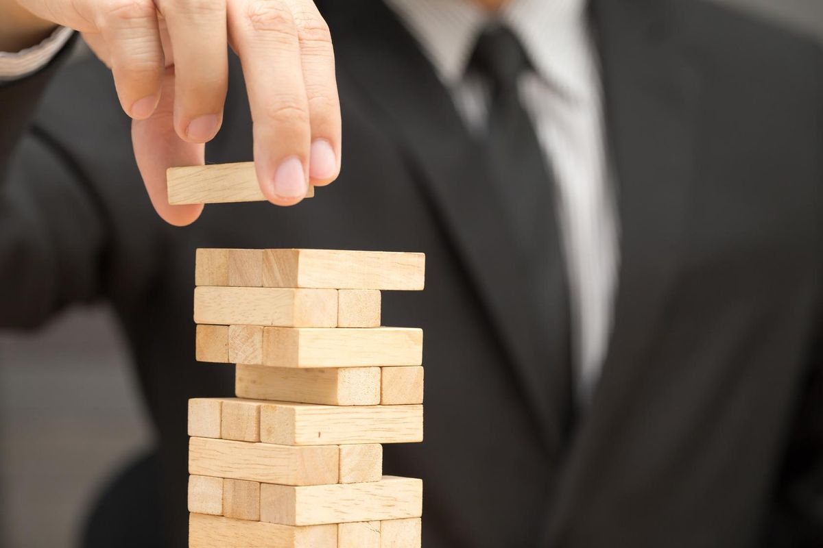 Businessman placing wooden block on a tower