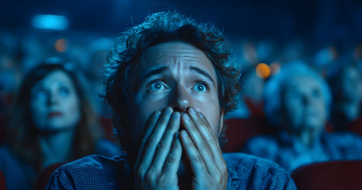 Horror, man and movie in theater with shock for spooky scene