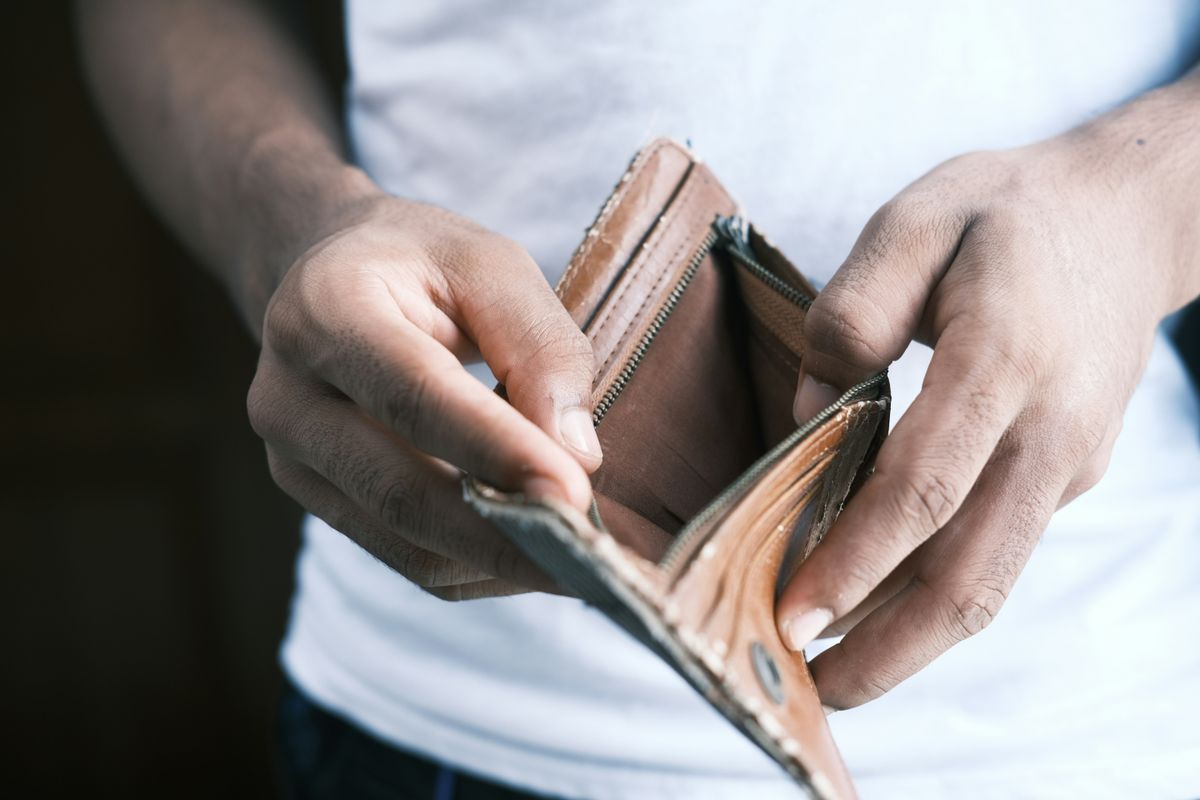 Man opening his empty wallet