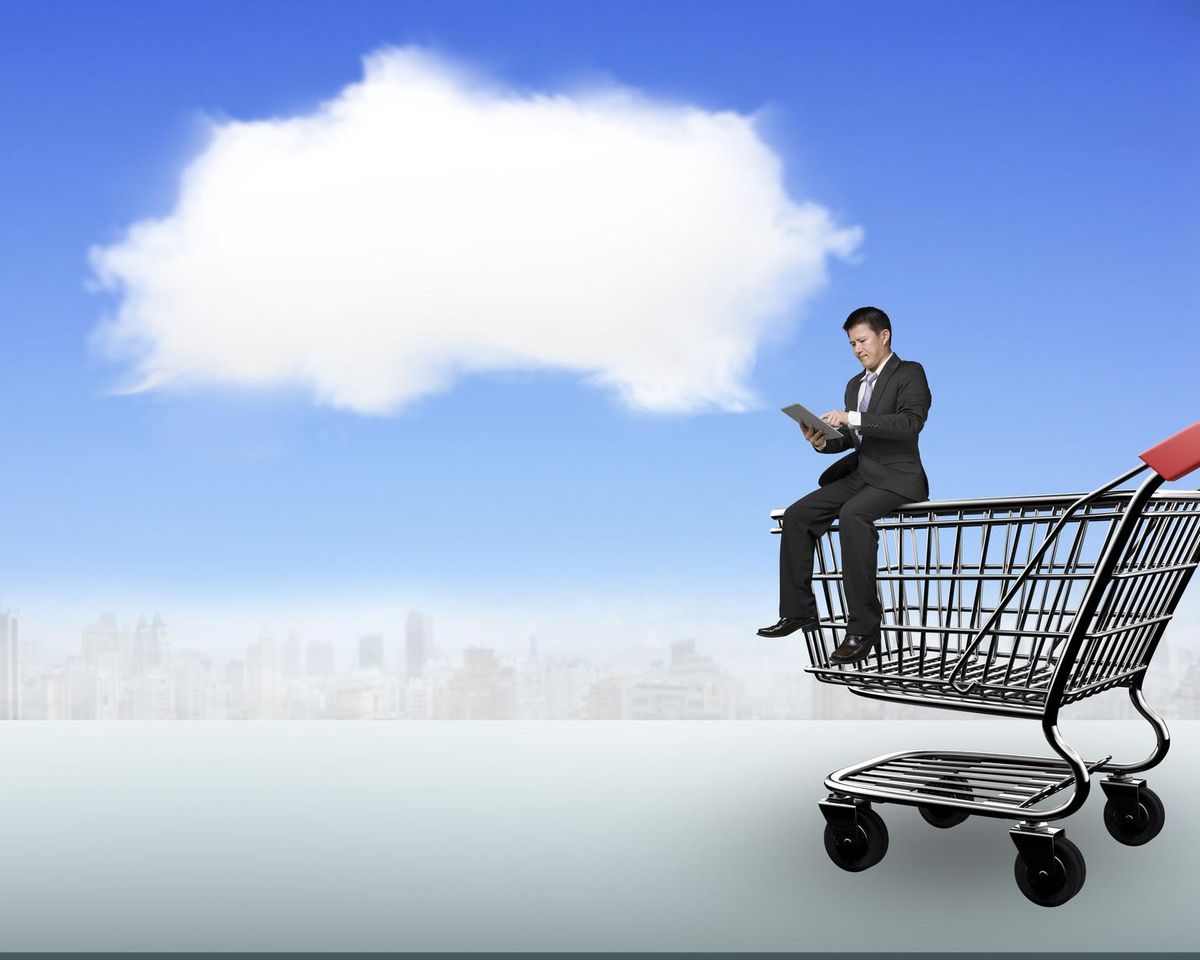 Man using tablet sitting on shopping cart with white cloud