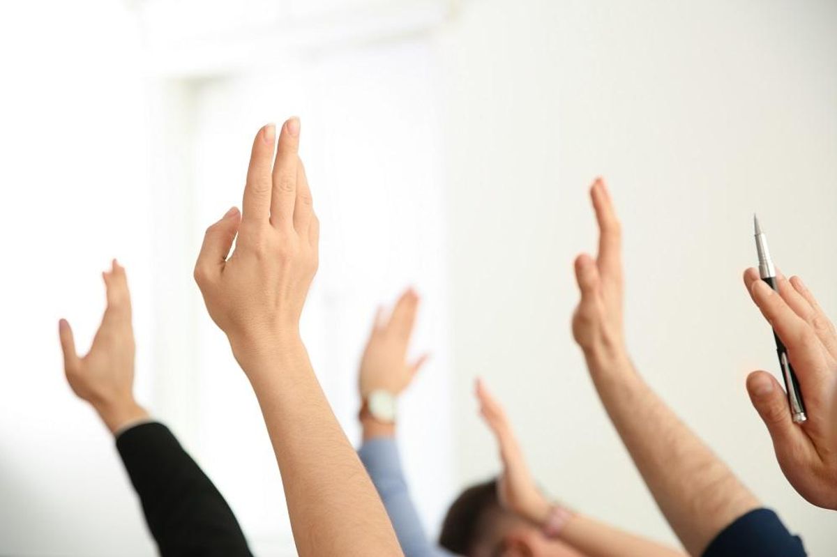 People raising hands to ask questions